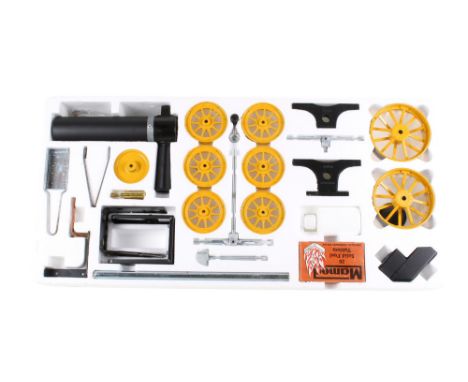 A Mamod live-steam Tractor and Log Trailer kit. In black with yellow wheels and flywheel, unconstructed and complete, with th