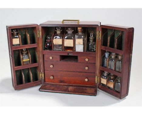 Early 19th Century mahogany apothecary cabinet, the sunken brass handle to the top above a pair of hinged doors enclosing bot