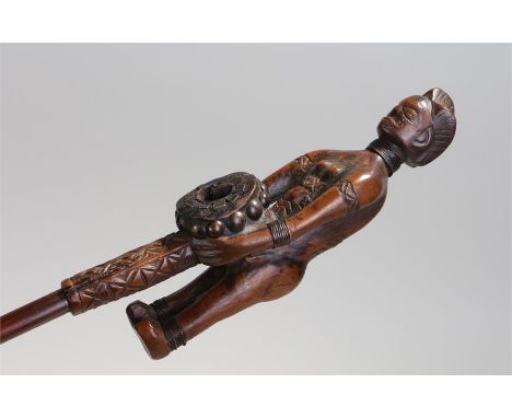 African figural pipe, carved with a figure holding the pipe bowl with a geometric design stem and tube end, 37cm high