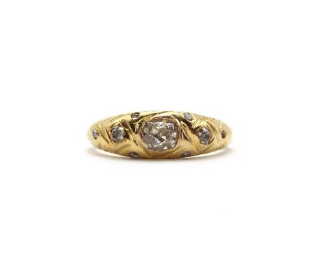 A gold diamond ring,with a row of graduated old brilliant cut, eight cut and rose cut diamonds, all gypsy set to the engraved