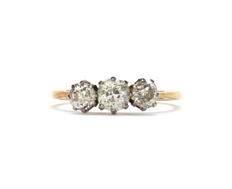 A gold three stone diamond ring,with a row of graduated old brilliant diamonds, claw set in white collets, to chenier shoulde