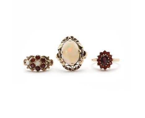 A gold single stone opal ring,the oval cabochon opal claw set to open gallery with floral and scroll decoration, to a plain s