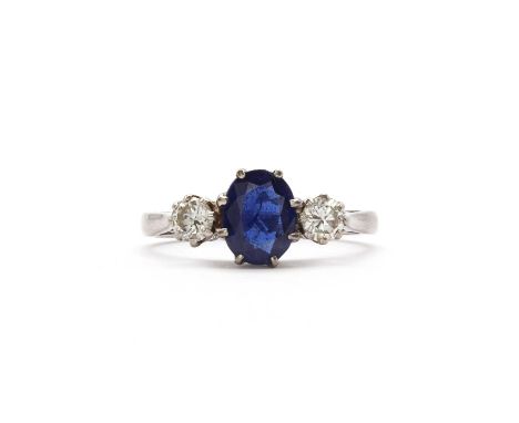 An 18ct white gold three stone sapphire and diamond ring,with an oval mixed cut sapphire claw set to rex collet, with a round