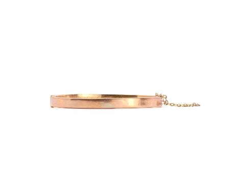 A 9ct hollow gold hinged bangle,the flat profile bangle, 5mm in width, to concealed box clasp and safety chain, engraved 'Mar