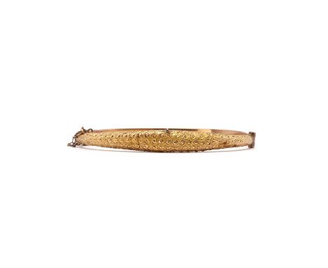 An Edwardian 9ct gold hollow hinged bangle,the tapered top half with chased scroll to a plain bottom half, to a concealed box