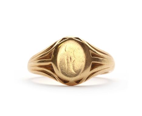 An oval signet ring,head almost plain, once engraved with a monogram. Incised shoulders, hallmarked 18ct gold, Chester 1911, 
