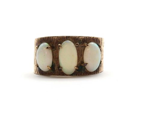 A graduated three stone opal ring,with a bark textured shank, tested as approximately 9ct gold. 4.84g.Finger size S½ LECondit