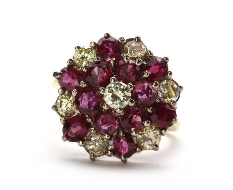 An 18ct gold ruby and diamond cluster ring,with a round brilliant cut diamond to the centre, surrounded by a border of round 