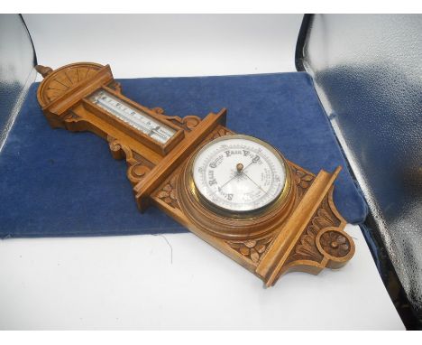 Oak Cased Barometer with carved design . 23 inches long including finial 