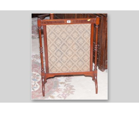 An Edwardian mahogany framed silk fronted firescreen with turned supports on arched feet, 31 x 22 ins (79 x 56 cms)