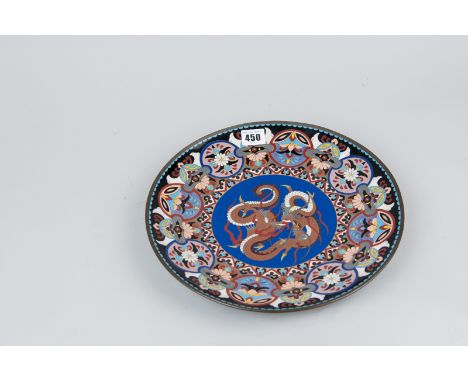 An Oriental cloisonne plate with central swirling dragon decoration on a blue ground and repeating floral pattern border, the