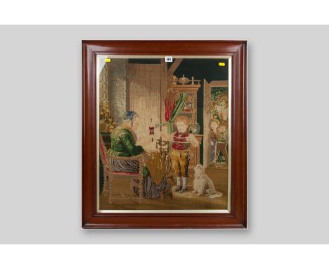 A Victorian mahogany framed woolwork tapestry showing a humorous interior scene of a young boy and an elderly woman at a spin