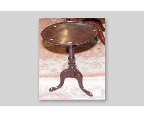 A Georgian mahogany tilt top table, the dished tray top on turned column support and tripod base, 25 ins (63.5 cms) high, 20.