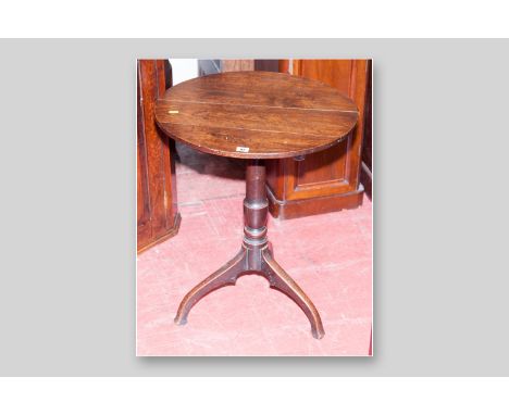 An early oak circular topped tripod table with turned column support and splayed legs, 21 ins (53.5 cms) diameter