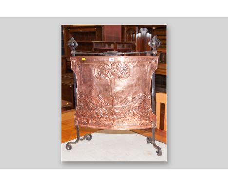 A wrought iron and copper Art Nouveau firescreen with raised stylized floral pattern, 30 x 25 ins (76 x 63.5 cms)