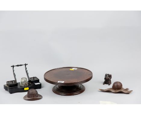 A Victorian mahogany 'Lazy Susan', 10.5 ins (26.5 cms) diameter, three carved wooden inkwell holders and an ebony desktop sta