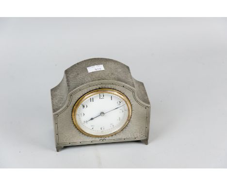 A beaten pewter mantel clock on corner bracket feet with French brass movement and white enamel dial, the base stamped 'Perio
