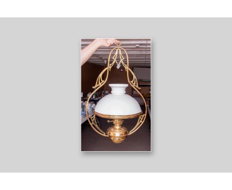 A late Victorian hanging brass oil lamp with polished brass font and white shade, 27 x 18 ins (68.5 x 46 cms)