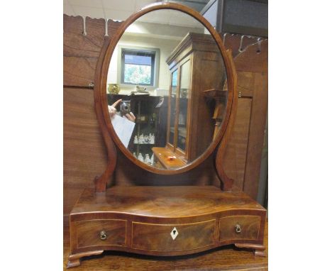 An oval mahogany dressing table mirror with three drawers  