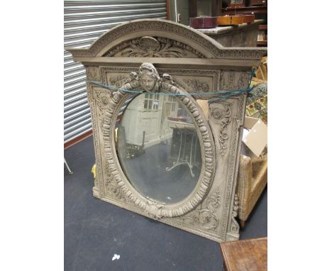 An architectural overmantle mirror, oval in a grey painted and carved frame, 156 x 143cm  