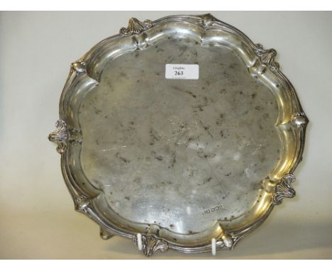 A silver shaped circular salver on three feet, Sheffield 1910, 18ozs, 27cm diam  