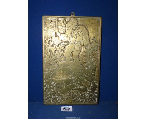 A heavy brass plaque of an explorer and a helmet from a suit of armour