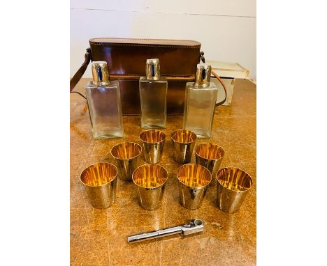 A travelling decanter set with eight shot cups and a bottle opener 
