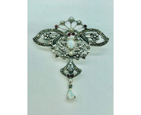 A silver art nouveau style brooch set with rubies and opal 