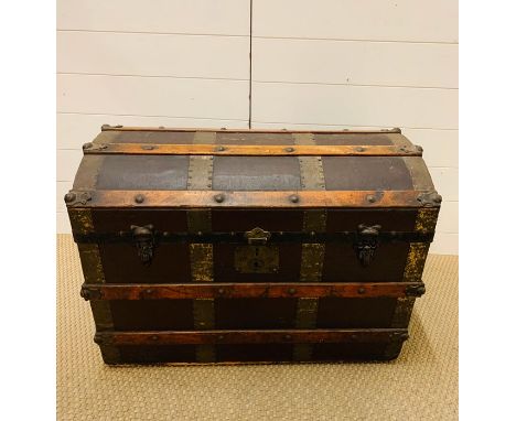 A vintage brass and wooden banded curved trunk 