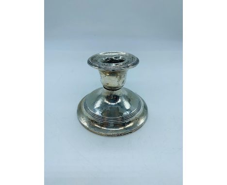 A silver hallmarked candlestick of squat design, AF broken.