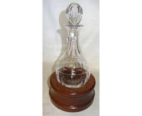 A Cumbria Crystal glass Decanter with rounded bottom in a wooden stand, boxed. 