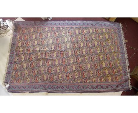An early 20th century woollen carpet decorated with stylised repeating floral motifs with an outer border of pale blue, 270 x