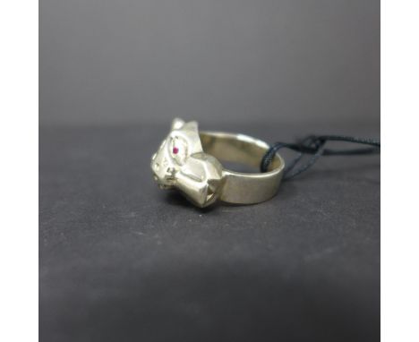 A contemporary, sterling silver ring in the form of a stylised leopard head set with ruby eyes, Size: O, 20g 