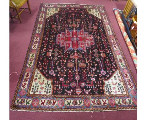 A North-West Persian Nahawand carpet, central diamond medallion with repeating animal and petal motifs on a midnight field, c