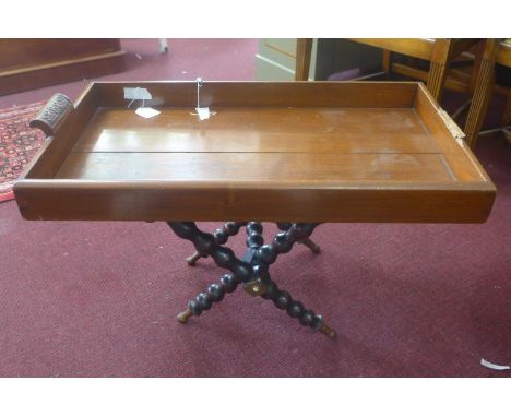A mahogany tray on folding X-frame stand with bobbin turned supports, one handle broken to tray, H.46 W.75 D.42cm 
