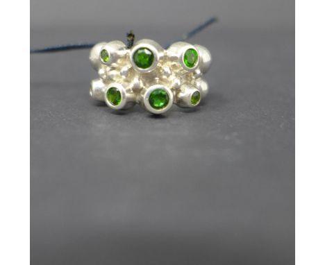 A sterling silver, chunky contemporary ring set with 7 round faceted green garnets, Size: O, 11.5g 