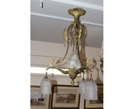 An Art Nouveau design gilded brass three branch light fitting with ribbed frosted glass shades