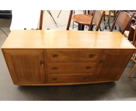 A light Ercol sideboard, fitted three central drawers flanked by cupboards, 156cm wide 