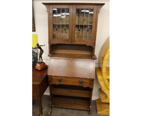 An Arts & Crafts oak bureau bookcase, the upper section enclosed by a pair of glazed leaded light doors, fall front, single d