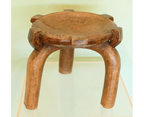 A late 19th century African hardwood tribal stool, circular dished top over three simplistic curved supports.diameter 32.5cm,