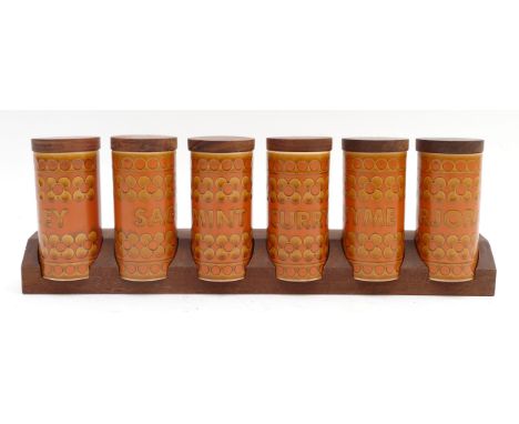 Six Hornsea Pottery Saffron spice jars with associated mahogany rack.
