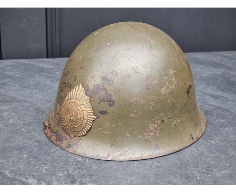 A Korean War Thai infantry steel helmet, with lining, chinstrap&nbsp;and badge, purposed from a WWII Japanese Helmet and with