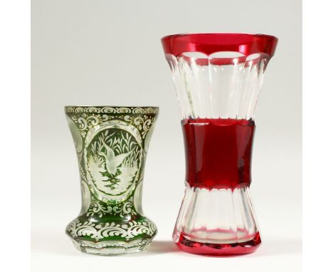 A BOHEMIAN GREEN BEAKER, engraved with deer and ducks, 5.5ins high, and A RUBY TINTED VASE, 8ins high (2).