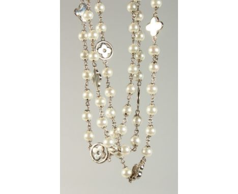 A long decorative pearl necklace, interspersed with flower head design. 145cm long.