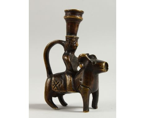 AN EASTERN SMALL BRONZE CANDLESTICK, modelled as a man riding a ram. 12cms high.
