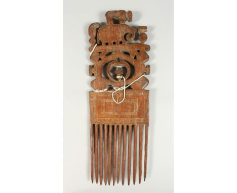 A TRIBAL CARVED WOOD COMB, monkey on an elephant. 41cms high.