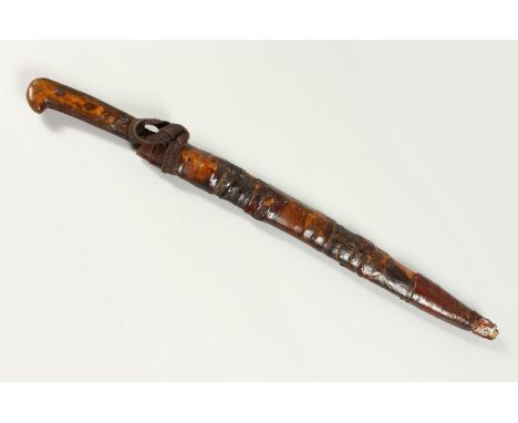 AN AFRICAN KNIFE, with horn handle and leather scabbard. 50cms long overall.