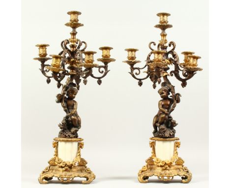 A PAIR OF 20TH CENTURY BRONZE, ORMOLU AND MARBLE FIVE BRANCH, SIX-LIGHT CANDELABRA, with cherub supports. 58cms high.