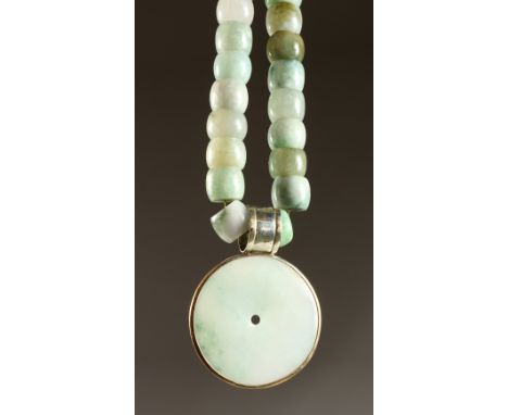 A GOOD HEAVY JADE NECKLACE with circular pendant.