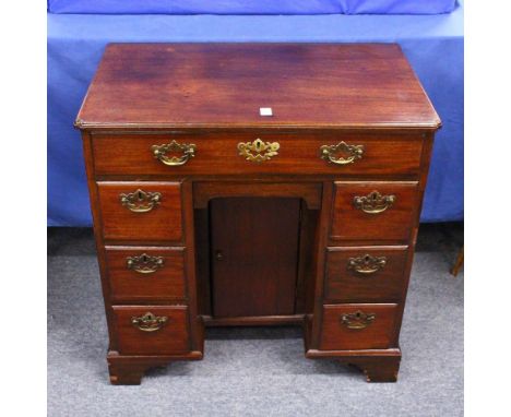 A GEORGE III MAHOGANY KNEEHOLE DESK, with a single frieze drawer, central cupboard flanked by three drawers to each side, on 